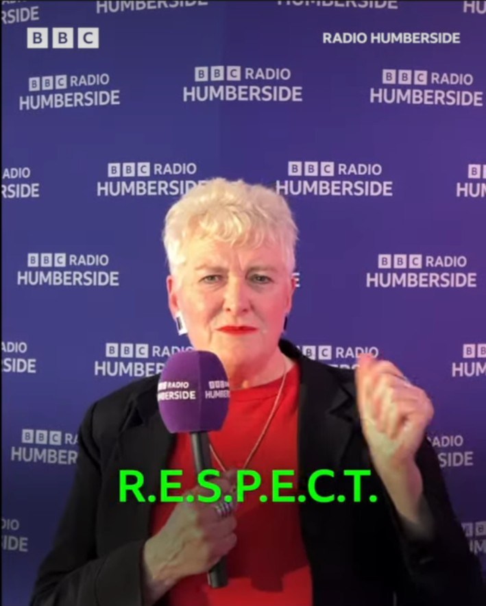 A mayoral candidate in red being interviewed by BBC Radio Humberside